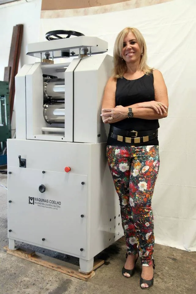 Lucilia Coelho ao lado de um laminador LG 300 da Máquinas Coelho